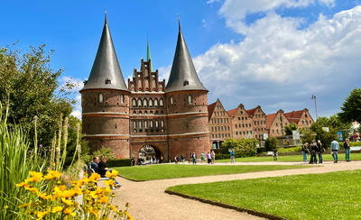 Das Holstentor, eine Sehenswürdigkeit in Lübeck mit blauem Himmel und Blumen.