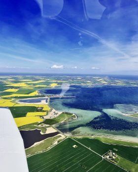 Ostseeküste bei Fehmarn während der Rapsblüte auf einem Rundflug. Der Ausflug startete in Lübeck.